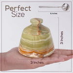 Decorative stone with measurements on a hand and spoon for scale