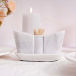 A beige marble onyx salt and pepper shaker set with a tray, displayed on a table with a soft background.