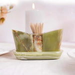 A beige marble onyx salt and pepper shaker set with a tray, displayed on a table with a soft background.